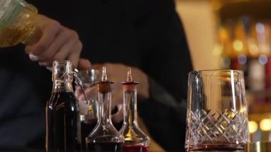 İçki şekerini ölçmek için elinde jigger tutan yakın el barmeni bardakları karıştırmak için alkol hazırlama yaratıcı karışım. Gece hayatı karışımı sergilenen özel bir içecek. Vinosity.