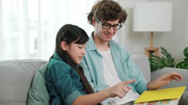 Beyaz bir baba ve tatlı bir kız kanepede otururken masal kitabı okuyorlar. Mutlu bir baba, sevimli bir Amerikan çocuğuna, birlikte zaman geçirirken hayal gücünün gelişmesi için hikaye anlatıyor. Pedagoji.