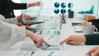 Çağdaş bir ofis ortamında finansal raporlar ve dijital grafikleri analiz eden çeşitli iş adamları bir araya geldi. SACTR