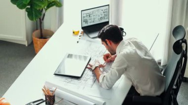 Kafkasyalı yetenekli, gevşemiş inşaat mühendisi mola zamanında elinde planla masada uzanıyor. Profesyonel mimar, dizüstü bilgisayar ve ekipman üzerinde çalıştıktan sonra uyuyor ve dinleniyor. Hizalama.