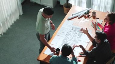 Proje yöneticisi çalışırken ve kahve içerken iç mimari planlama binasının üst görüntüsü. Bir grup mühendis fikir üretiyor ve fikir sunarken ev yapısını tasarlıyor. Sempozyum.