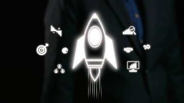 Bir roket ikonunun dinamik görüntüsü iş büyümesini ve başarıyı simgeler. Çevreleyen grafikler finans, teknoloji ve yeniliğin yönlerini gösteriyor. Girişimci temalar için ideal. Dörtgen