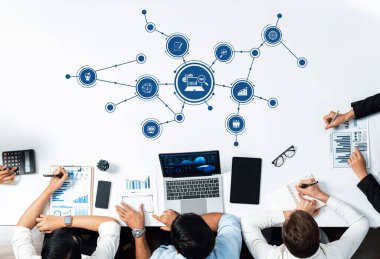 Modern ofislerdeki takım çalışması ve dijital veri stratejilerinin altını çizen, dizüstü bilgisayarlarındaki grafik ve çizelgeleri analiz eden profesyonellerle yapılan bir iş toplantısının havadan görüşü. Dostluk