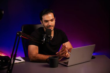 Yayıncı, fanclub dinleyicisiyle mikrofon kullanarak konuşuyor. Mor neon ışıklı modern stüdyoda yaratıcı olumlu düşünce konseptiyle canlı yayında finansal sorunları tartışıyor. Tahmin et..