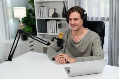 Sunucu kanalı, gülümseyen akıllı yayıncı kaydı, senaryosu ve akıllı telefonuyla sosyal medyada sohbet programı, kulaklık takarak modern ev stüdyosundaki video flamalarını kaydediyor. Bireysel.