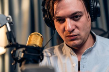 Sunucu kanalı akıllı yayıncı canlı sosyal medyada kamera önünde yüz portresi yapıyor. Etkilenen yayıncı, modern ofis stüdyosunda kulaklık takıyor. Bireysel.