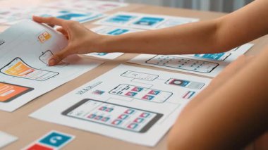 Mobil uygulama için kullanıcı arayüzü prototipi ya da masadaki program modeliyle birlikte web sitesi planlaması yapan bir şirket çalışanı. UX UI tasarımcısı kullanıcı dostu arayüz planını dikkate alır. Sinerjik