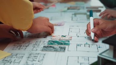 Bireylerin planlama ve tasarlamada işbirliği içinde olduğu canlı bir çalışma alanı. Çeşitli eller planlar ve numunelerle etkileşime girer, yaratıcılığı eylem halinde gösterir. SACTR