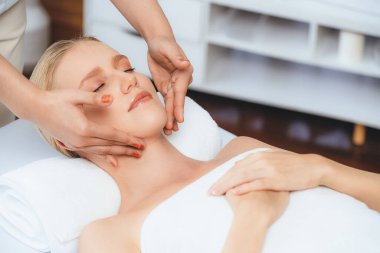 Kafkasyalı kadın stres önleyici kafa masajından ve lüks tatil beldesi ya da otel spa salonundaki modern ışık ortamında yüz güzelliği eğlencelerini şımartmaktan hoşlanıyor. Sessiz.