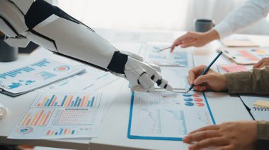Bir robot kol, modern bir ofiste verimli bir toplantı sırasında iş analizi, veri görselleştirme ve stratejik planlamayı gösteren bir insan takımıyla işbirliği içindedir.
