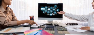 Masadaki bir grup iç mimar takımı dizüstü bilgisayarında mimari yazılım bulunan çeşitli ruh hali tahtası örneklerini seçiyor. Modern yenileme ve iç malzeme seçimi konsepti. İçgörü