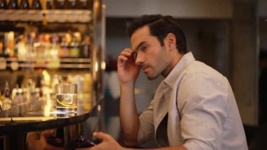Akıllı adam, cuma gecesi lüks bir bar ve restoranda gece kulübünün karşılama barında arkadaşlarıyla sohbet ederken tek başına kokteyl içiyor. Vinosity.