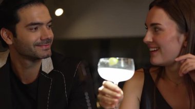 Lezzetli tadını çıkarmak için martini kokteyli içen bir kadın, çiftle canlı sohbetler ederken, margaritanın tadını çıkarırken, gece kulübü barında özel bir an yaratıyor. Vinosity.