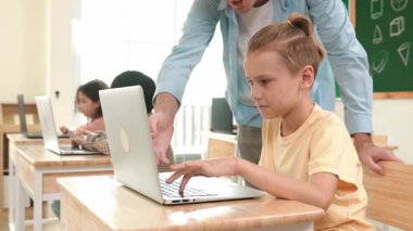 Çeşitli öğrenciler yapay zeka yazılımı kullanırken, Kafkas öğretmeni enerjik çocuğa kodlama konusunda yardım ediyor. Çocuklar oturma ve programlama sistemi. Sevimli bir öğrenci şifreyi öğreniyor. Pedagoji.