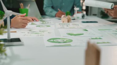 Sürdürülebilirlik ve büyüme üzerine kurulu dinamik bir iş toplantısında, profesyonel bir çalışma alanındaki tablolar ve stratejik belgeler üzerinde tartışmalara katılan eller ele alındı. SACTR