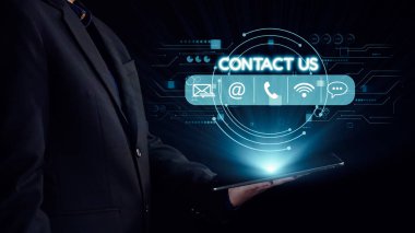 Bir işadamı, iş dünyasının dijital arayüzü karşısında modern iletişim teknolojisini gösteren sanal temas simgelerini gösteren bir tablet tutuyor. Dörtgen