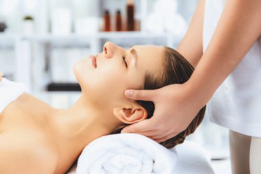 Kafkasyalı kadın stres önleyici kafa masajından ve lüks tatil beldesi ya da otel spa salonundaki modern ışık ortamında yüz güzelliği eğlencelerini şımartmaktan hoşlanıyor. Sessiz.