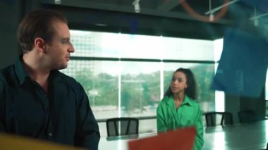 Profesyonel iş adamları yaratıcı pazarlama fikrini modern ofiste tartışırlar. İş adamları cam tahtada yapışkan notlar kullanarak finansal plan üzerinde çalışıyor. Yönlendirici.