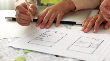 Mimari ekipmanlarla toplantı masasında ev tasarımı üzerine profesyonel mühendis ekibi tartışması ve modern ofiste bina planı dağılımı. Eline odaklan. - Yakın çekim. Tanımlama.