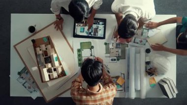 Akıllı mimar mühendisinin planlarını mimari ekipmanlar kullanarak ölçerken tasarımcılar toplantı odasında bina tasarımı ya da ev inşaatı hakkında konuşuyorlar. Hizalama.