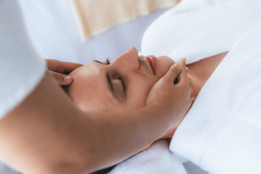 Beyaz adam stres önleyici kafa masajından ve lüks bir tatil beldesi veya otel spa salonundaki modern ışık ortamında yüz güzelliği eğlencelerini şımartmaktan hoşlanıyor. Sessiz.