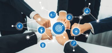 Dinamik bir iş ekibi işbirliği içinde birleşiyor, el ele tutuşarak takım çalışması sergiliyor. Dijital bağlantılar ortak hedeflere ve başarıya olan bağlılıklarını sembolize eder. Dostluk