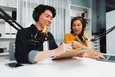 Gülümseyen radyo etkili sunucular, kulaklık takarak sosyal medya kanalından canlı yayın yapıyorlar ve sabah saatlerinde stüdyo kaydında dinleyicilere konu ve dizüstü bilgisayar üzerinden konuşuyorlar. İnfobahn.