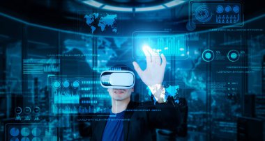 VR gözlüklü bir proje yöneticisi mali tabloyu ve ofisteki parlak mavi ışığı gösteriyor. Yetenekli iş adamı artırılmış gerçeklikten elde edilen verileri kullanarak pazarlama stratejisini kontrol edip planlıyor. Yaratıcılık.