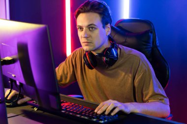 Kazanmak için çevrimiçi oyun oynayan akıllı flama makinesinin sunucu kanalı, neon ışıklı odada seçilen takım yarışması için izleyicilerle birlikte canlı yayında canlı yayında kulaklık takıyor. Bireysel.