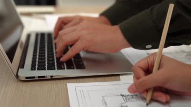 Mimari ve güvenlik mühendisi, modern ofiste doğruluk için mimari belge ve ölçüm aracına dizüstü bilgisayardaki inşaat ayrıntılı planlarını yazar. - Yakın çekim. Tanımlama.