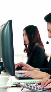 Ofiste çalışan kulaklık takan işadamları uzak müşteri ya da meslektaşlarını desteklemek için çalışıyorlar. Arama merkezi, tele pazarlama, müşteri destek acentesi telefon görüşmesinde hizmet sunar.