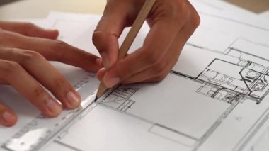Ölçüm aracı ve kalem el kullanan akıllı mimar veya akıllı mühendisin videosu mimari ofisteki inşaat hatasızlığı için ayrıntılı bir tasarım hazırladı. Eline odaklan. - Yakın çekim. Tanımlama.