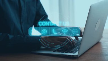 Profesyonel bir birey modern ofis ortamında dizüstü bilgisayar kullanır. Sanal iletişim ve bağlantı seçeneklerini vurgulayarak sahneyi dijital temas simgeleri kaplar. Dörtgen