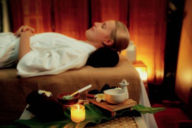 Aromaterapi masajı ambiyansı ya da spa salonu kompozisyon düzeneği bulanık kadınlara odaklı dekor mumları ve spa aksesuarları ile tatil köyü veya otel arka planında keyifli aroma spa masajı yapan. Sessiz.