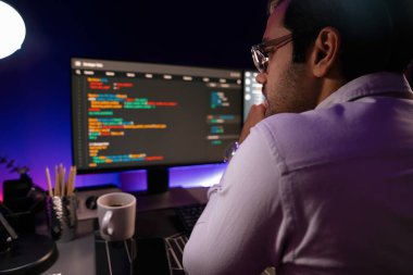 İki pc ekranda veri yazılım geliştirme analizi yapan akıllı bilişim geliştiricisi, neon ışıklı siber ofiste güncellenmiş uygulama programı güncellenmiş online web sayfası sistemi yaratıyor. Tahmin et..