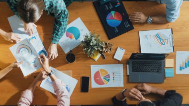 Proje yöneticisinin veri ve mali tabloyu analiz etmek için tablet kullanırken pazarlama ekibinin pazarlama kampanyası ya da toplantı odasında planlama stratejisi üzerinde birlikte çalışmasının en üst görüşü. Cemaat.