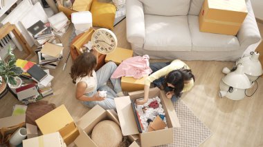 Kutuları açan ve mobilyaları toplayan mutlu arkadaş manzarası. Karton kutuyla çevrili oturma odasında konuşurken yeni daireye taşınan çekici bir genç. Malikane. Myrmidon.