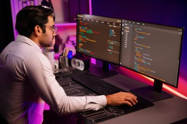 İki pc ekranda veri yazılım geliştirme analizi yapan akıllı bilişim geliştiricisi, neon ışıklı siber ofiste güncellenmiş uygulama programı güncellenmiş online web sayfası sistemi yaratıyor. Tahmin et..