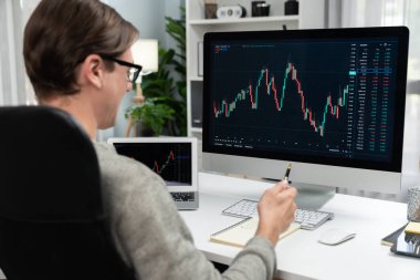 Akıllı borsa yatırımcıları bilgisayar ve laptop ekranından ilginç borsa takası seçmek için komisyoncuları arıyor, modern işyerindeki veri grafiğine gerçek zamanlı olarak bakıyor. Bireysel.