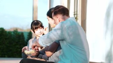 Güzel bir evlilik çifti ve kızı açık terasta piknik yapıyor. Açık hava aktivitelerini kullanan aile, çocuk için iyi bir büyüme, güçlü bir aile bağı ya da ilişkiyi güçlendirmek için sevgi ve özen göstermektedir. Uyumsuzluk.