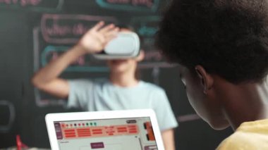 Afrikalı erkek programlama sistemi, beyaz bir kız karatahtanın başında mühendislik kodlarıyla otururken metaverse 'e giriyor. Liseli kız STEM teknolojisinde VR ya da kulaklık takıyor. Öğretim