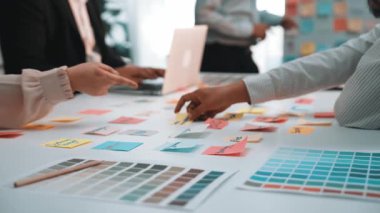 Renkli paletler, notlar ve yeni fikirler ve tasarım stratejileri geliştirmek için araçlar kullanan çeşitli profesyonellerin yer aldığı canlı bir ofis. SACTR