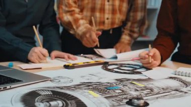 Dinamik bir ekip, modern ofis ortamında yaratıcılık ve yenilik sergileyen dizüstü bilgisayarlar ve araçlar kullanarak teknik çizimler ve mühendislik tasarımları üzerinde işbirliği yapar. SACTR