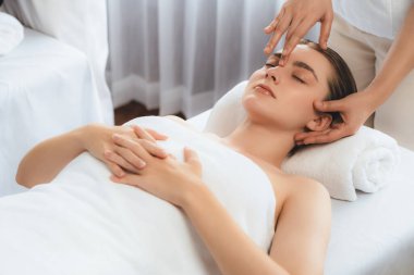 Kafkasyalı kadın stres önleyici kafa masajından ve lüks tatil beldesi ya da otel spa salonundaki modern ışık ortamında yüz güzelliği eğlencelerini şımartmaktan hoşlanıyor. Sessiz.