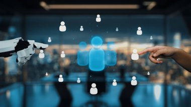 Bir insan eli, dijital simgelerle çevrili modern ofis ortamında robot bir ele uzanıyor. Bu görüntü, teknoloji ve insan işbirliği arasındaki bağlantıyı vurguluyor. Auvana