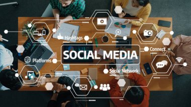 Sosyal medya kavramları, cihazlar, grafikler ve modern bir çalışma alanı ortamındaki tartışmalar üzerinde işbirliği yapan bir ekibin tepeden tırnağa görüşü. Dostluk