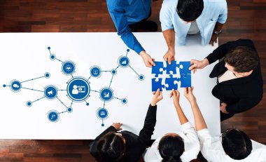 Takım üyeleri, modern bir ofis masasında veri grafiklerinde temsil edilen fikirlerin bir araya getirildiği bir dijital pazarlama stratejisi oturumuna katılıyorlar. Dostluk