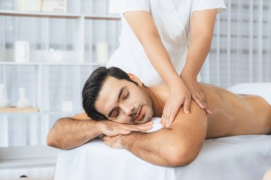 Kafkas erkek müşteri stres önleyici spa masajının keyfini çıkarıyor ve lüks otel veya oteldeki gündüz açık hava ortamında güzellik derisi eğlencesi ile şımartıyor. Sessiz.