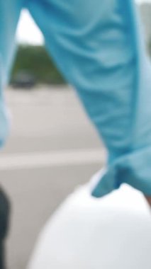 İlerici işadamı, şehir merkezinde dolaşmadan önce şarj cihazından elektrikli arabasına şarj prizi takıyor. Çevre dostu şarj edilebilir araba, sürdürülebilir ve temiz enerjiyle çalışıyor..