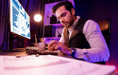 Akıllı iş adamı evrak raporlarını analiz eder, satış çeyreği online kanalı için kar ya da zarar hesaplar ürün servisinde hedef kitle pazar müşterisini neon karanlık ışık odasında karşılaştırır. Tahmin et..